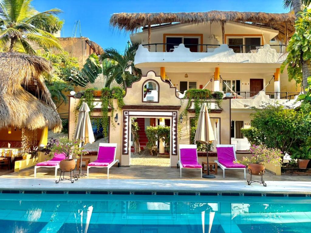 a resort with purple chairs and a swimming pool at BEACH HOTEL INES en Zicatela in Brisas de Zicatela