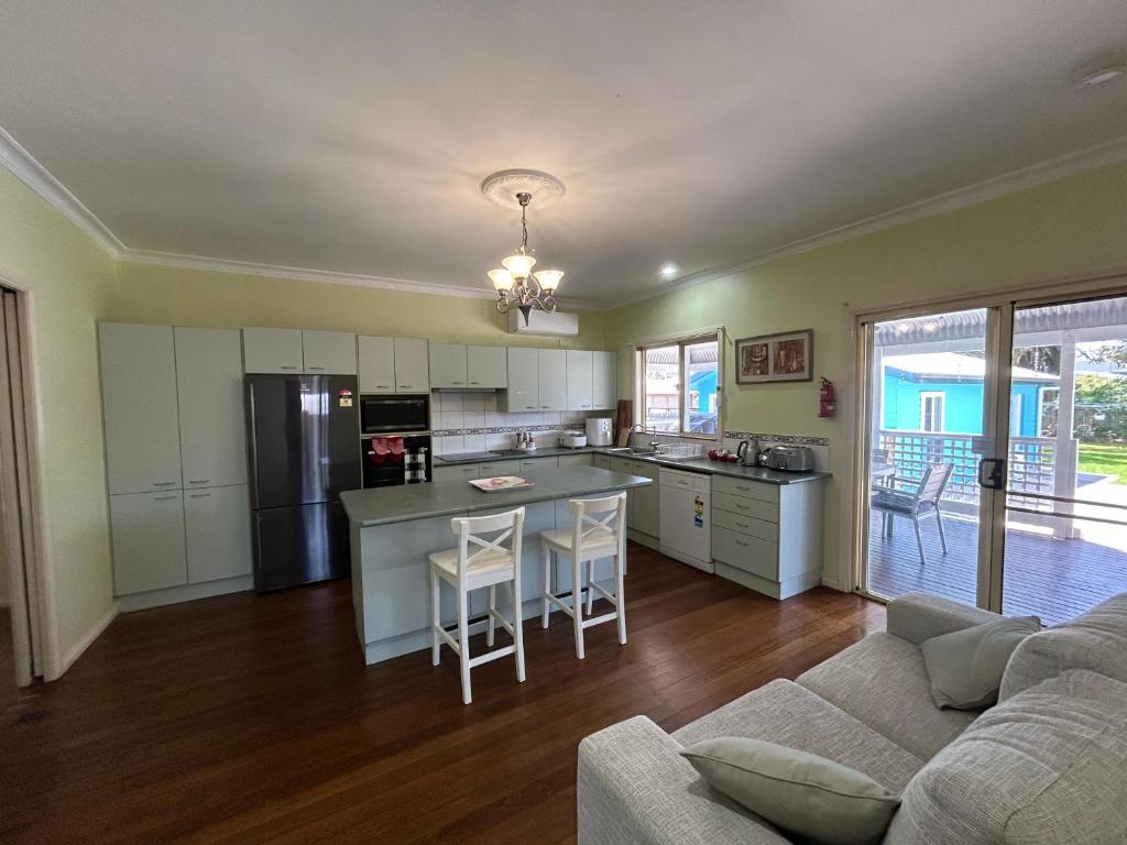 a kitchen and living room with a couch and a table at Spacious Stylish Coastal Escape in Tuncurry