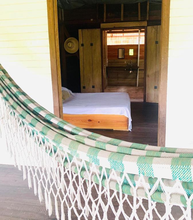 a hammock on a porch of a house at Una Habitación baño privado Casa Mango in Zapzurro
