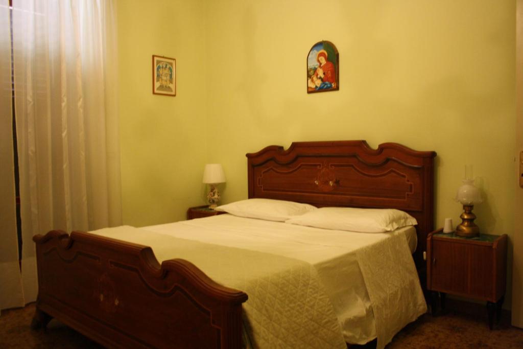 een slaapkamer met een groot bed met een houten hoofdeinde bij Agriturismo Casale 1921 in Torre le Nocelle