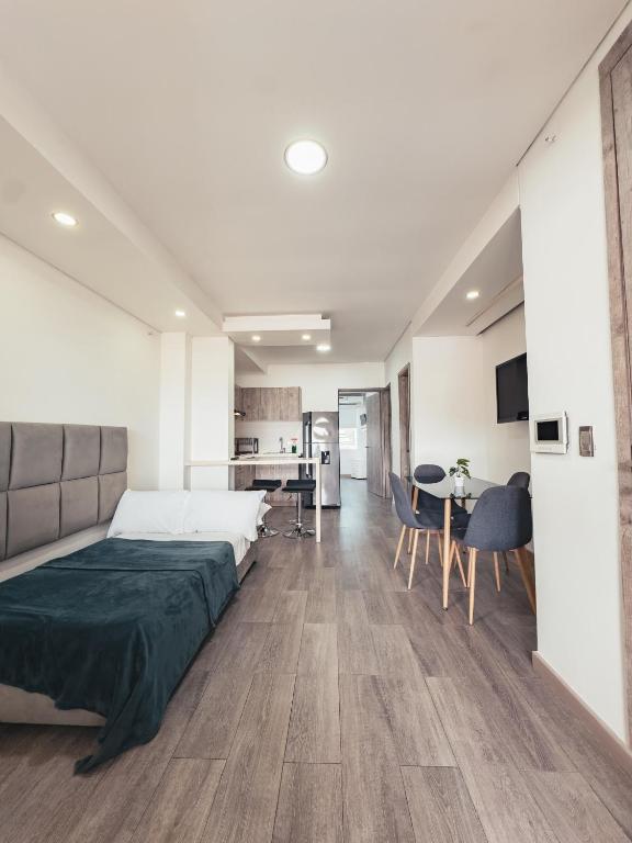 a bedroom with a large bed and a kitchen at Miraflores in Cali