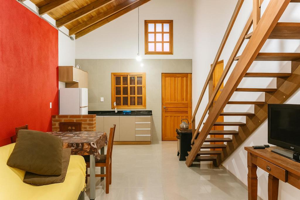 uma sala de estar com uma escada e uma cozinha em Casa da família Castro em Capão da Canoa