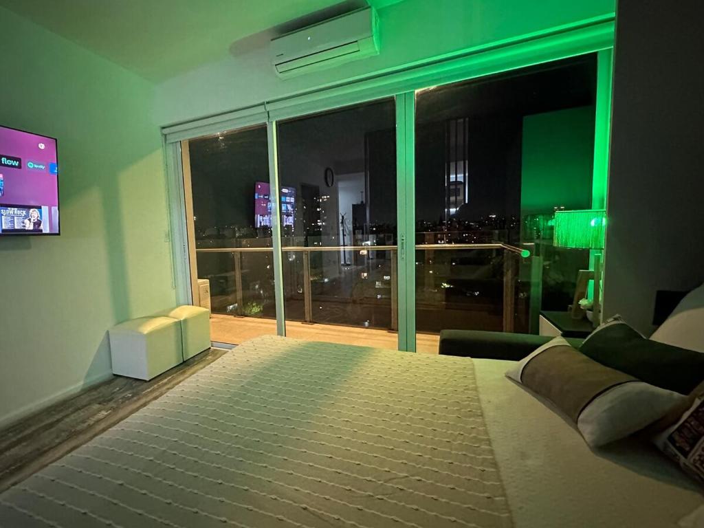a bedroom with a large window with a view of a city at Stylish Modern apartment with automatic parking in Buenos Aires