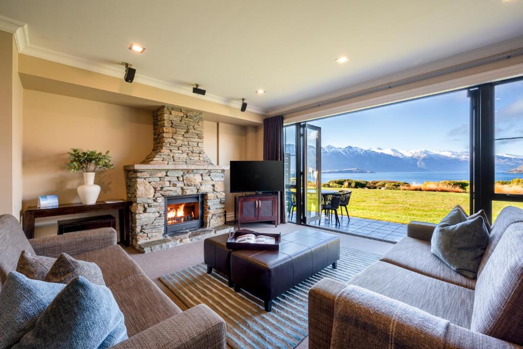 een woonkamer met een bank en een open haard bij Platinum Queenstown in Queenstown