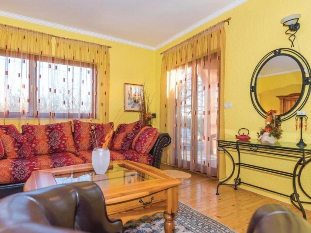 a living room with a red couch and a mirror at Holiday Home Marin AS with Pool in Trbounje