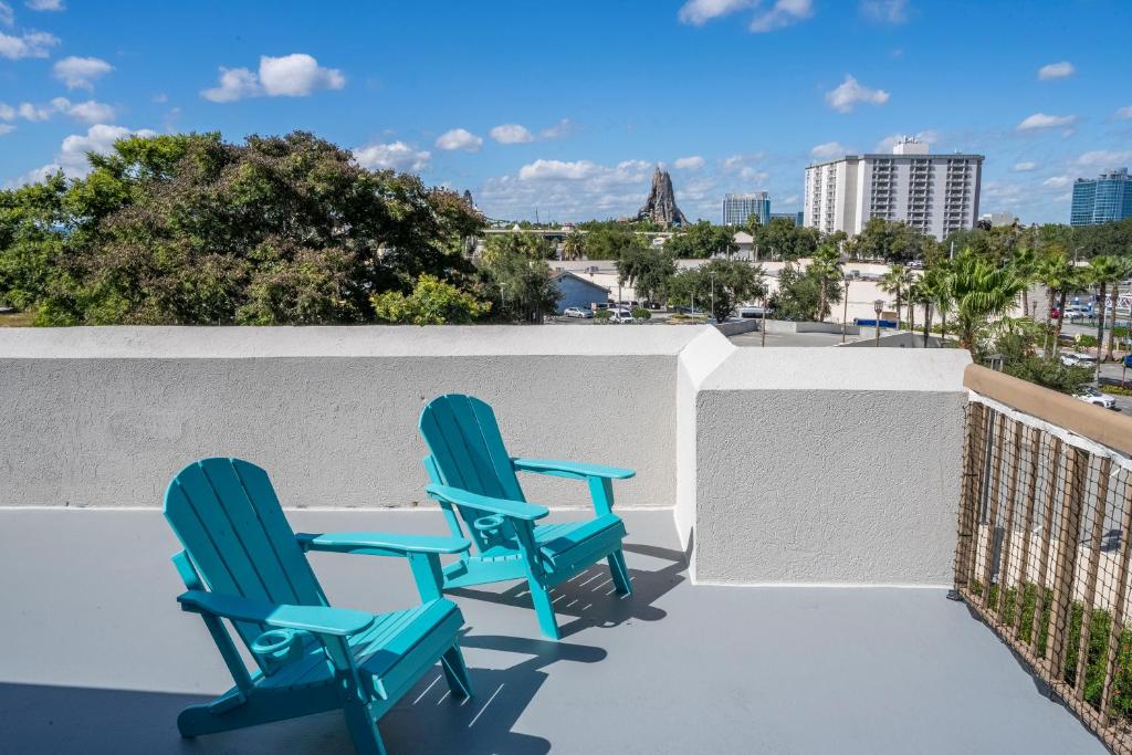 two blue chairs on a balcony with a view at Studio with Private Terrace and Volcano Bay View Near Epic Universe in Orlando