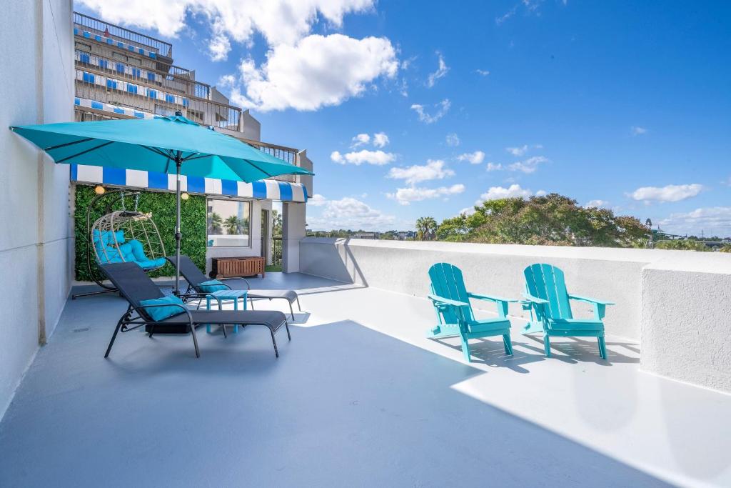 a patio with chairs and a table and an umbrella at New Studio with Private Terrace and Volcano Bay view 5 min EPIC parking free in Orlando