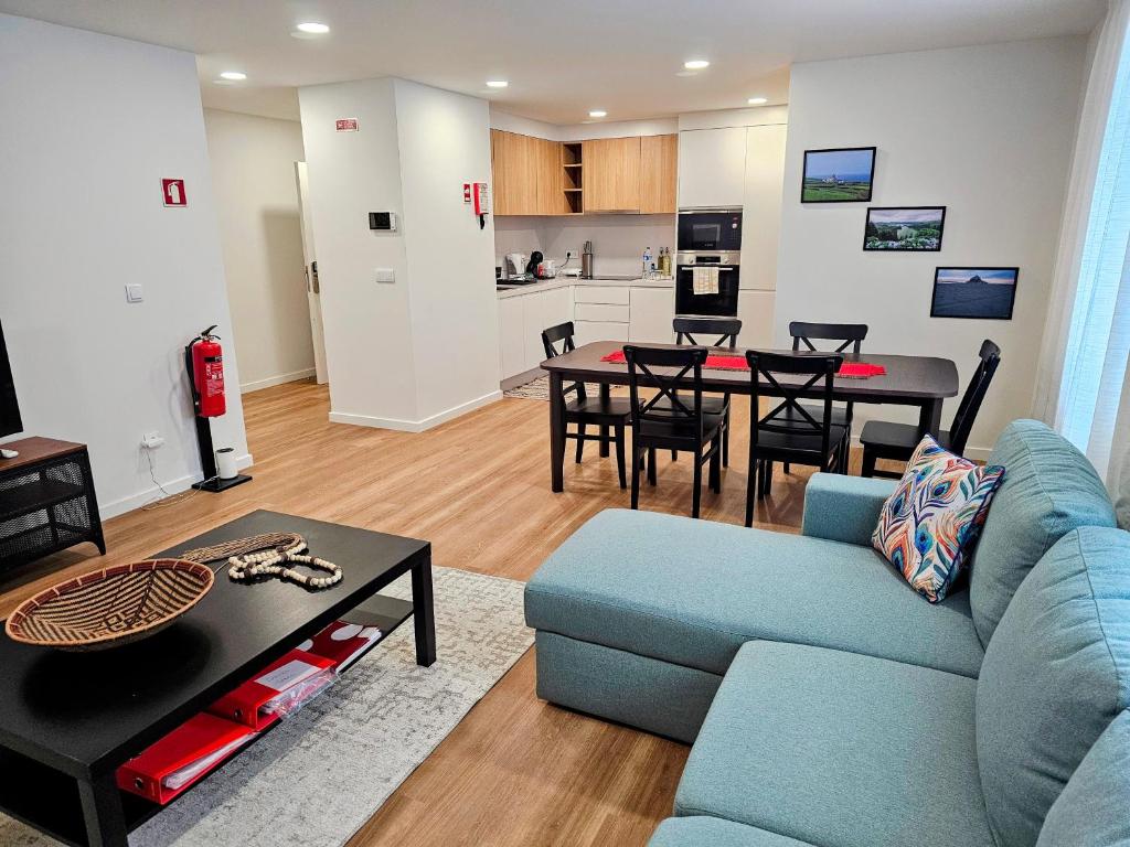 een woonkamer met een blauwe bank en een tafel bij Apartamento Sonho Terra in Ponta Delgada