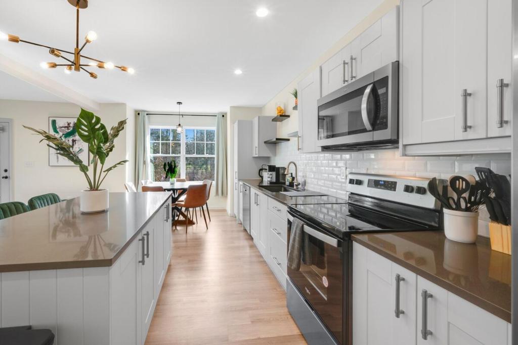 a kitchen with white cabinets and a counter top at Spacious 5BR Home KING Bed Wi-Fi Parking in Bloomfield