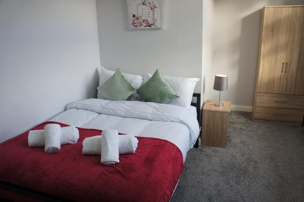 a bedroom with a large bed with towels on it at Melbourne House Gem Stylish 2-Bed in City Centre in Accrington