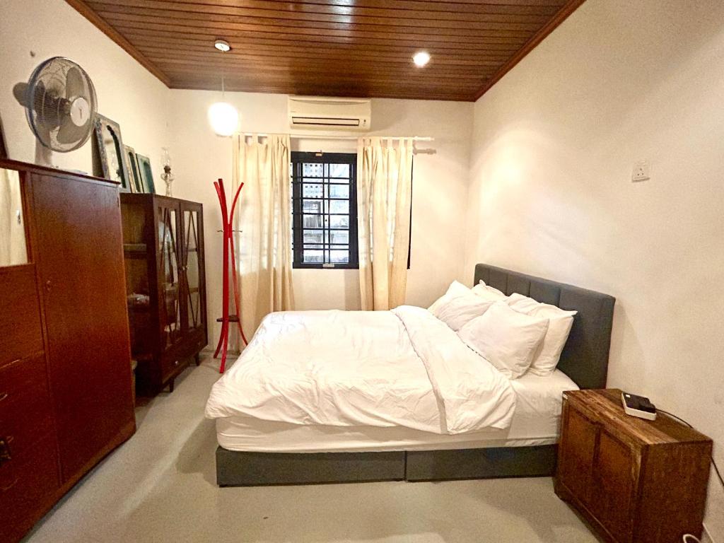 a bedroom with a bed with white sheets and a window at Chic Designer Room in Shared Bungalow SS1 Near LRT Petaling Jaya in Sungai Way