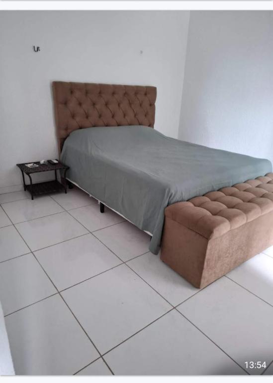 ein Schlafzimmer mit einem Bett und einem gefliesten Boden in der Unterkunft Casa linda in Ananindeua