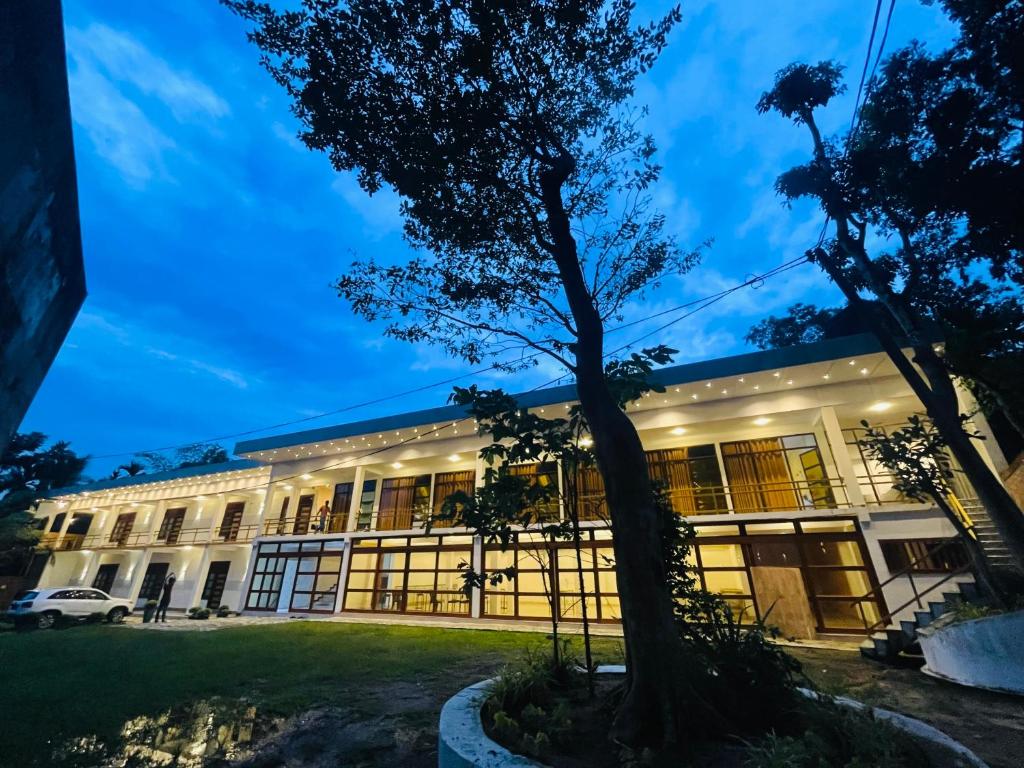 a building with a tree in front of it at Great Victoria Palace in Ratnapura
