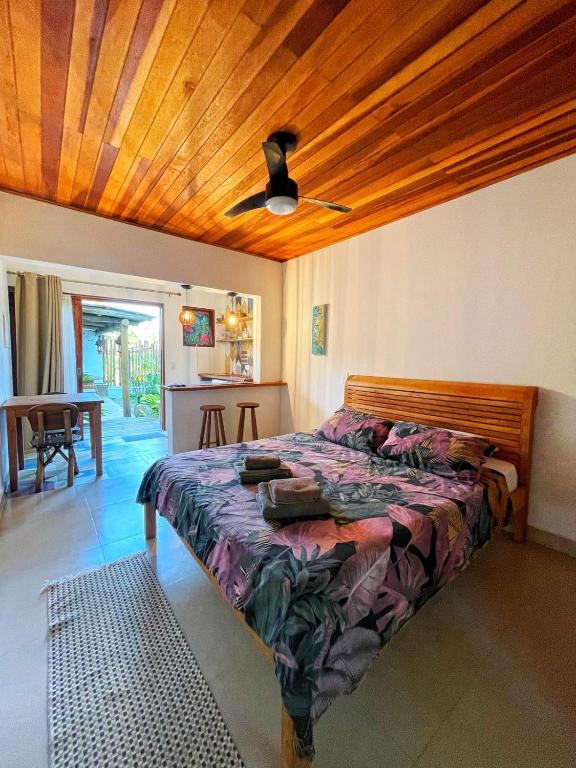 a bedroom with a bed and a wooden ceiling at Hakuna Studios Barra do Sahy in Barra do Sahy
