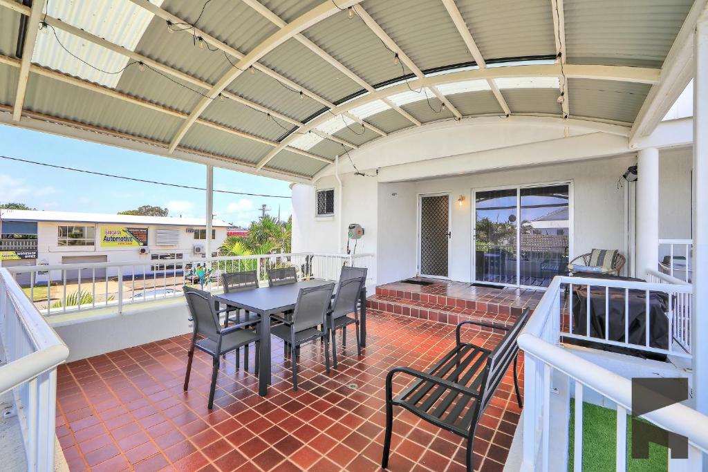 een terras met een tafel en stoelen op een balkon bij 1-20 Bauer Street in Bargara