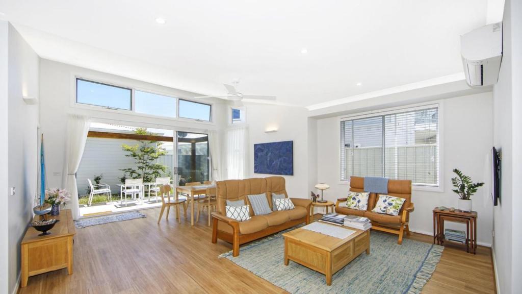 a living room with a couch and a table at Summer Splendor - Ettalong Beach in Ettalong Beach