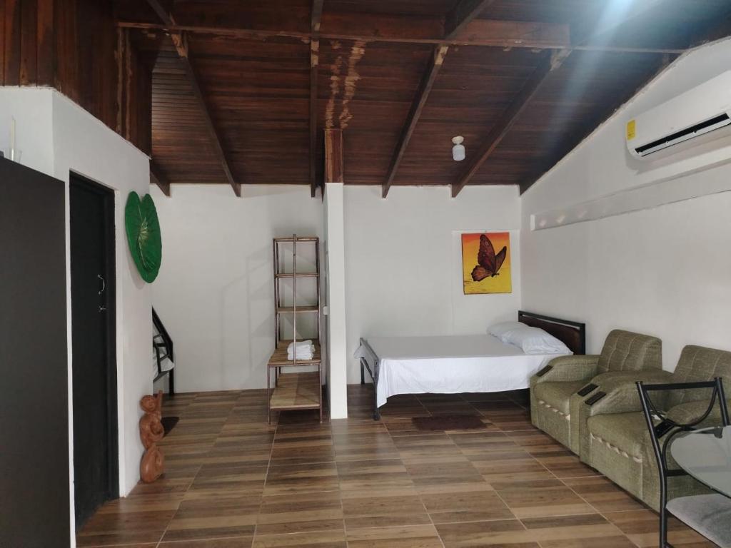 a bedroom with a bed and a couch in a room at Apartamentos GoZu # 1 in Puerto Viejo