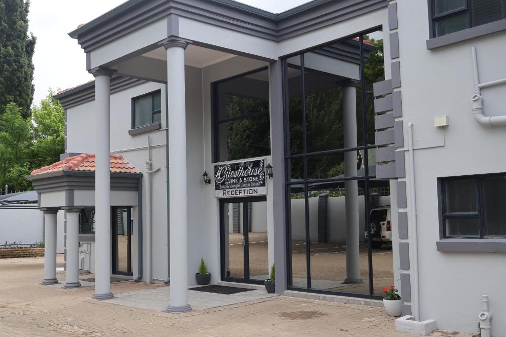 a white building with a sign in the window at GuestHouseVine&Stone in Clarens