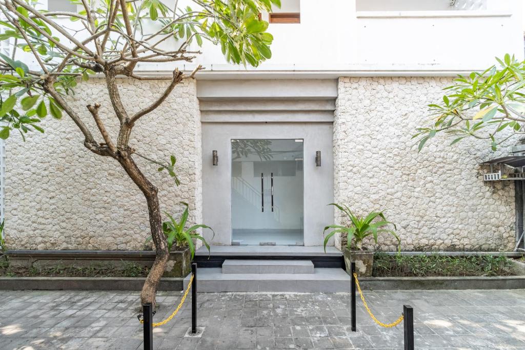 a front door of a building with a tree at Srikrisna in Seminyak