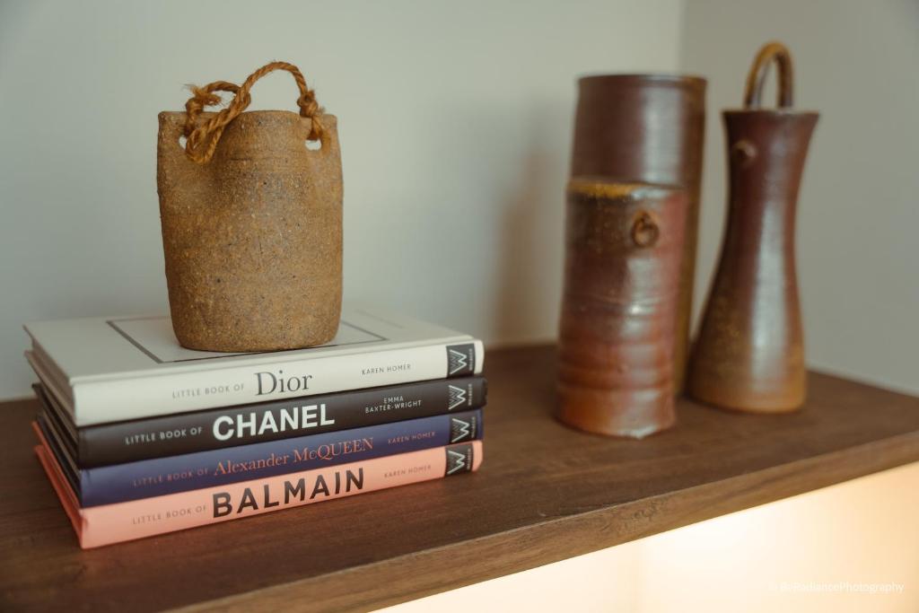 een stapel boeken op een plank met vazen bij The Luxe Haven at BGC in Sampong