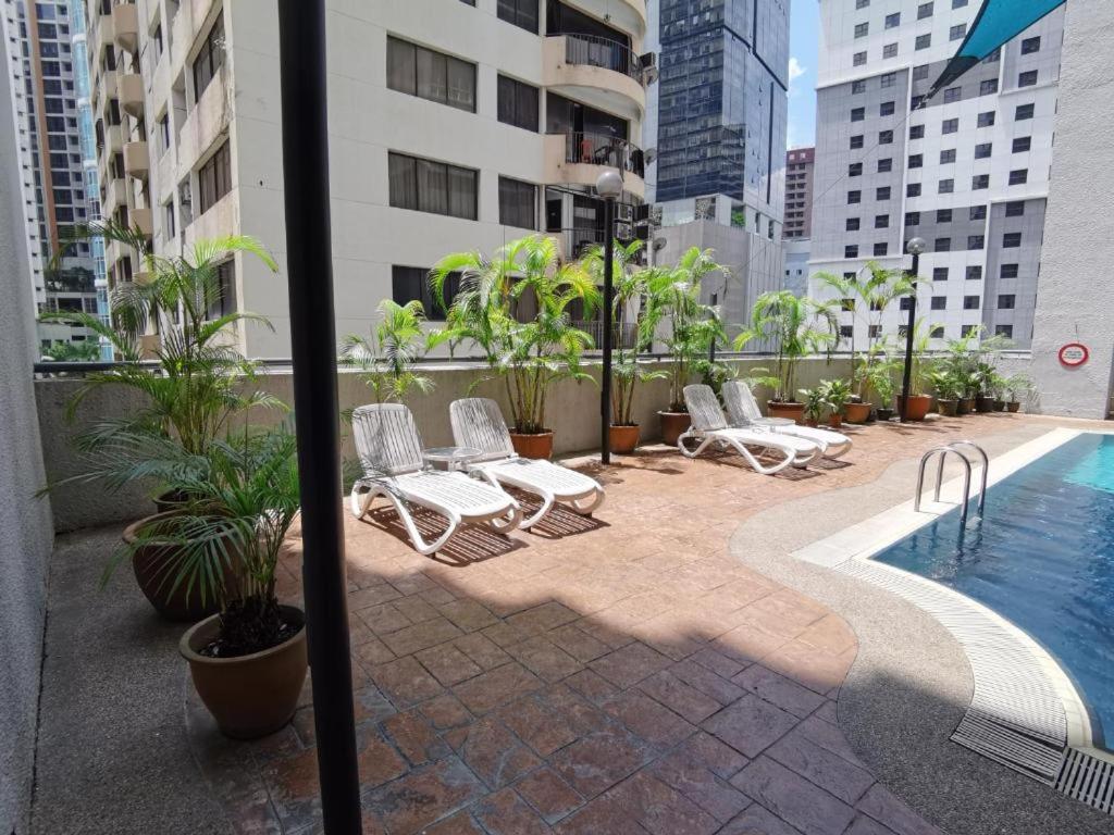 un patio avec des chaises et une piscine dans un bâtiment dans l'établissement Seri Bukit Ceylon Bukit Bintang, à Kuala Lumpur