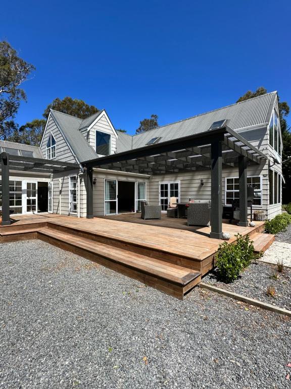 a house with a large wooden deck in front of it at Kaikōura Mountain View Lodge in Kaikoura