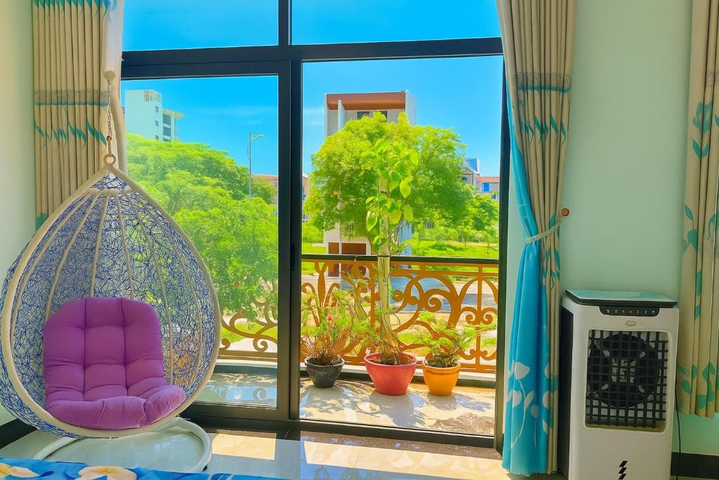 een kamer met een balkon met een stoel en een raam bij Lộc Vừng Homestay in Phan Thiet