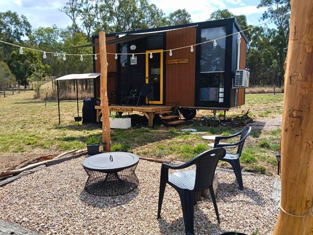 a tiny house on a trailer with a table and chairs at Kalmya Farm Retreat by Tiny Away in Nanango