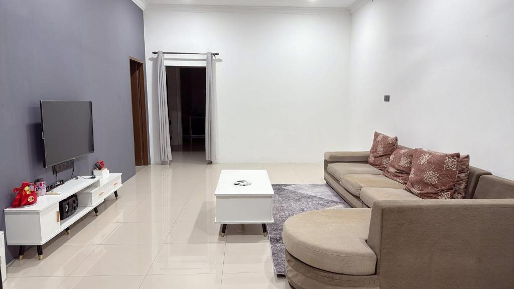 a living room with a couch and a tv at Homestay Sri Aman in Simanggang