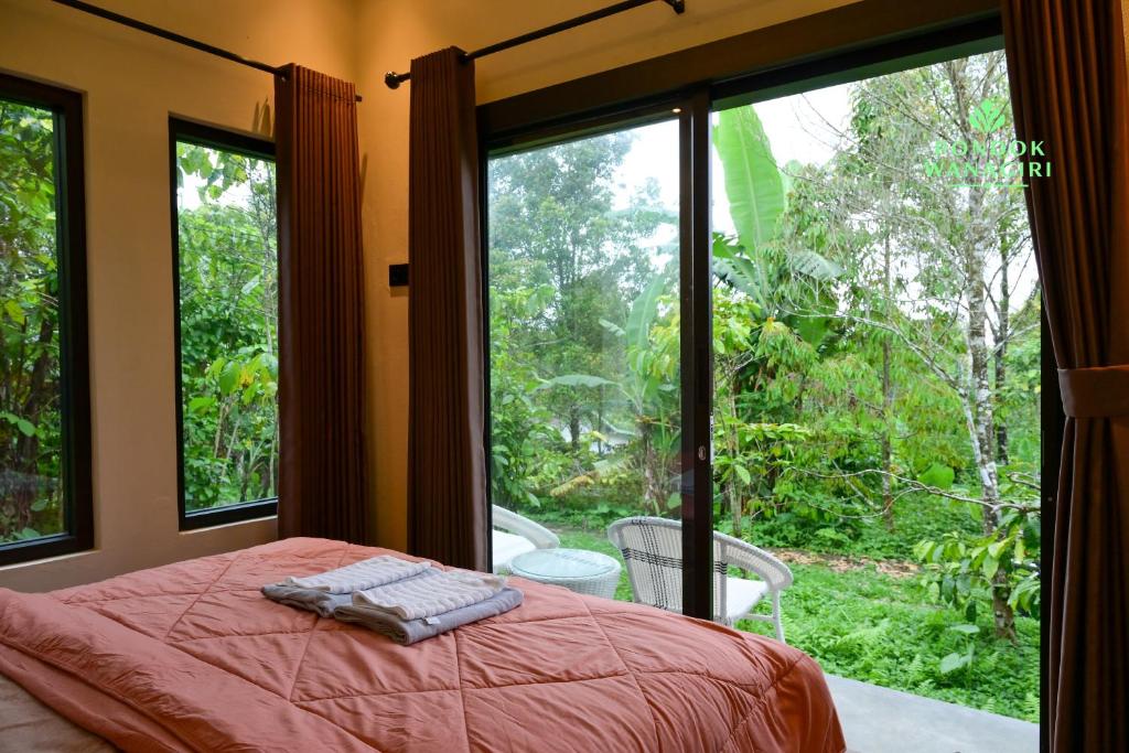 a bedroom with a bed and a large window at Pondok Wanagiri in Gitgit