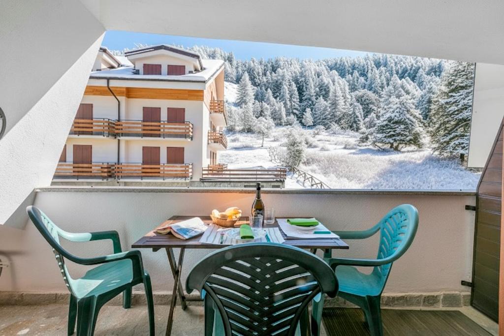 a table and chairs on a balcony with a view at Appartamento La Selva Incantata - Happy Rentals in Sauze d'Oulx