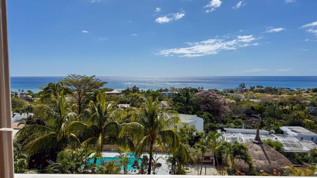 a view of the ocean from the balcony of a resort at LAKAZ DEL VISTA - Luxurious new apartments with panoramic sea views, pool & garden retreat in Tamarin