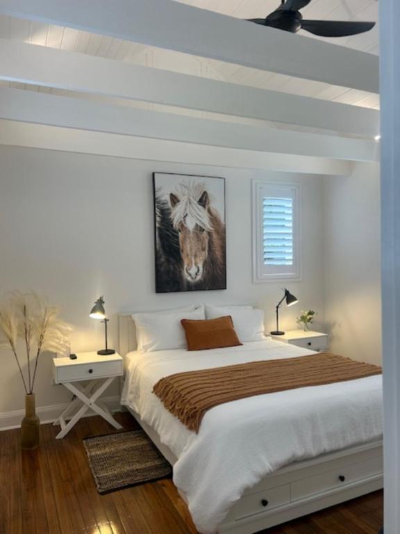 a bedroom with a bed and a painting of a cow at The Stables in Armidale