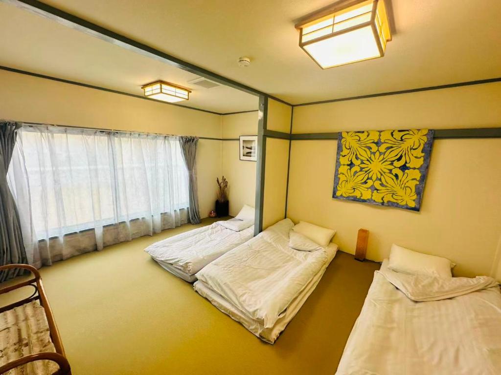 a room with two beds and a mirror at 時の宿 in Kawagoe