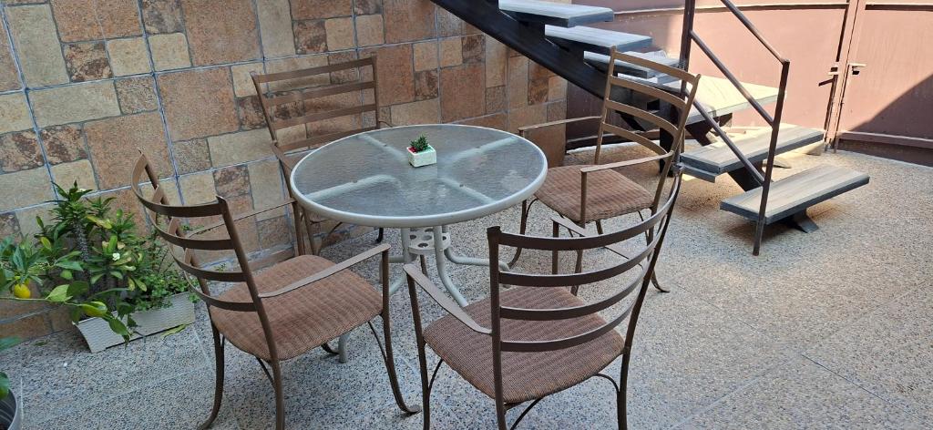 a glass table and chairs with a bottle on it at Noa Loft in Miravalle