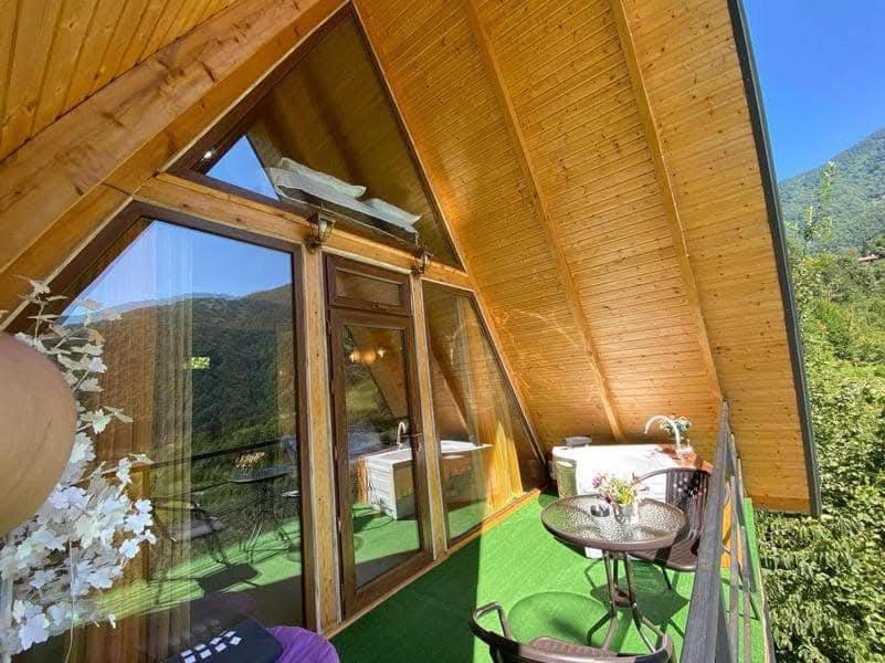 a house with a large glass window and a table at warm house - sunrise merisi in Merisi