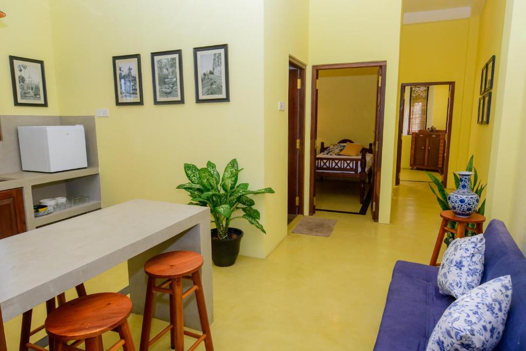 a living room with a blue couch and a table at Villa302 in Galle