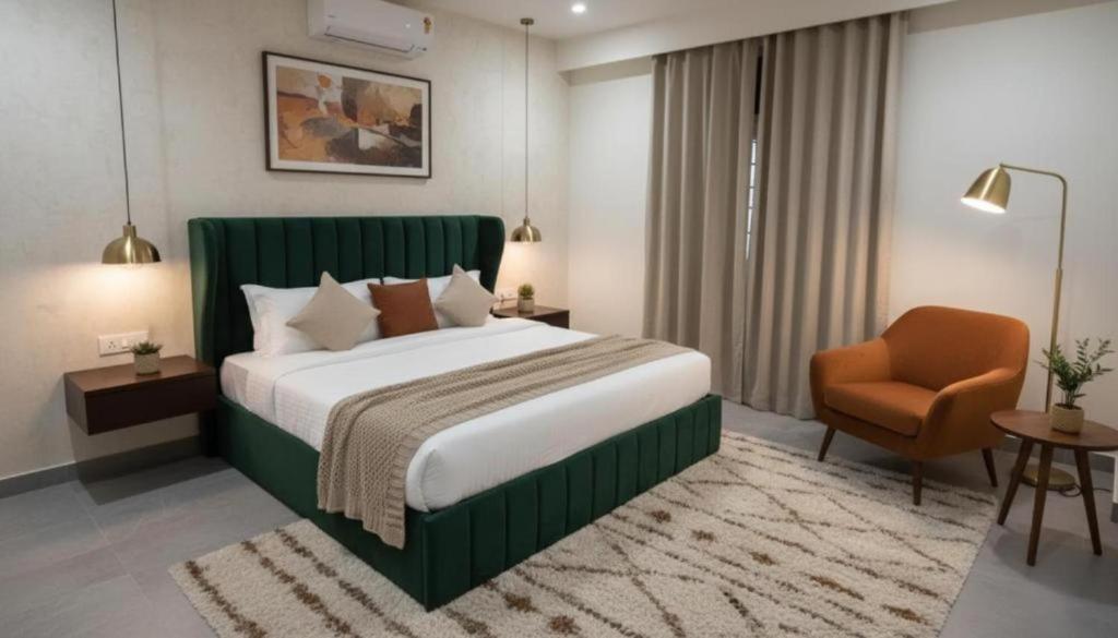 a bedroom with a green bed and a chair at Hotel Broholi Height Inn Near Hafeezpet Railway Station in Hyderabad