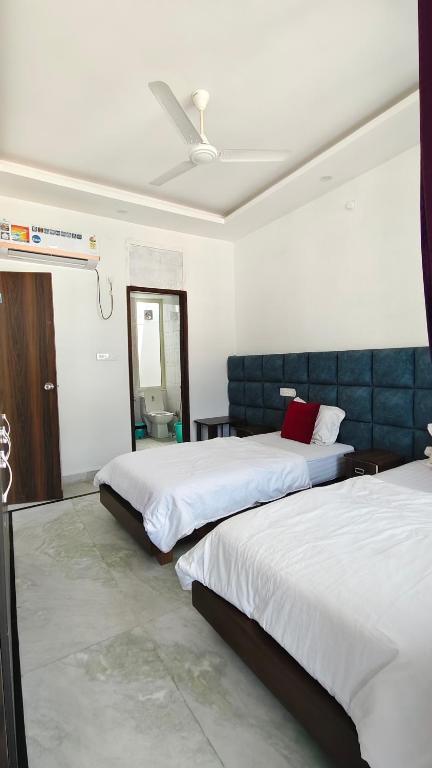 a bedroom with two beds and a mirror at Hotel Yoga Stay Rishikesh in Rishīkesh