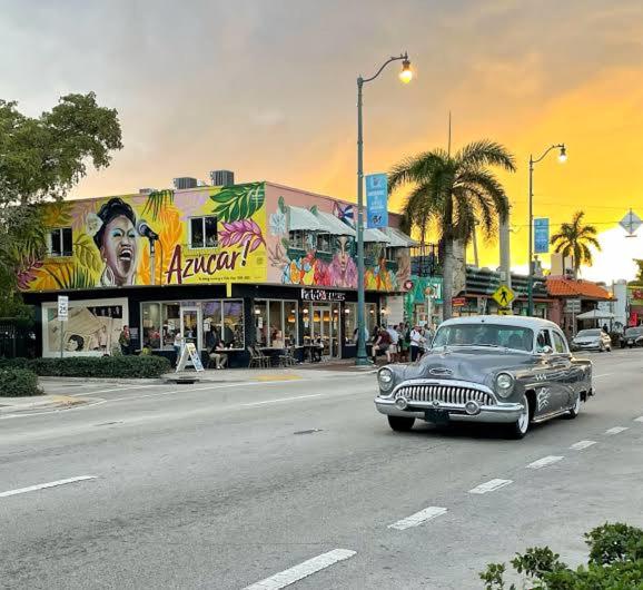 an old car driving down a street in a city at Tiny house WiFi and parking in Miami