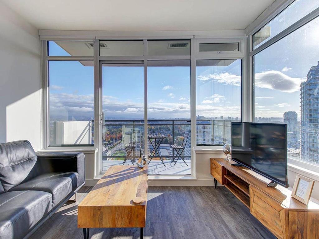 een woonkamer met een bank en een televisie bij Corporate Stays Hazel 1 Bedroom in Burnaby