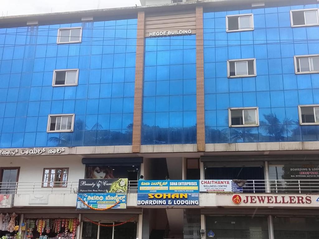 a blue building with signs on the side of it at Sohan Boarding and Lodging in Perdūru