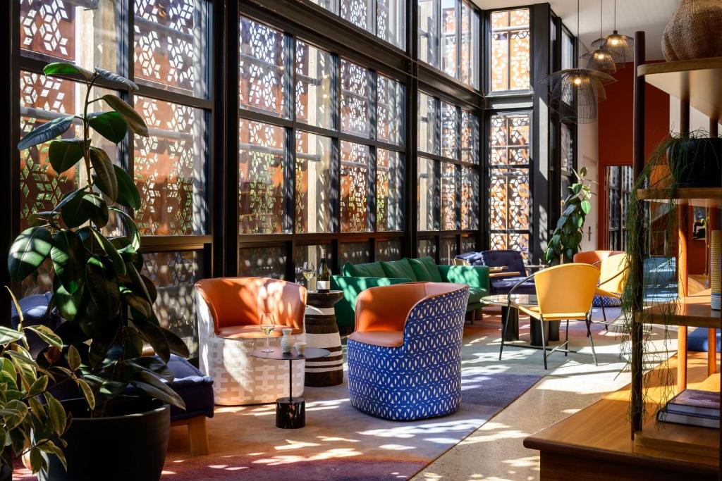 a room with a bunch of chairs and windows at Yallungah Boutique Hotel in Orange