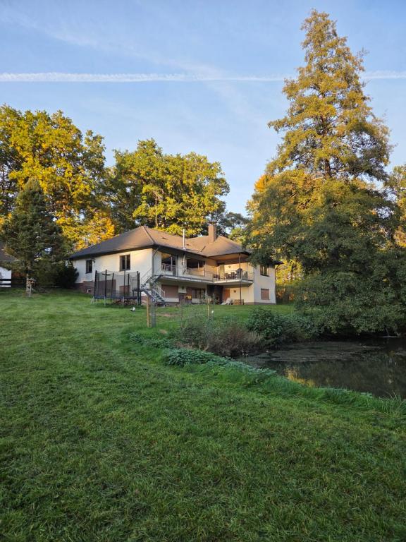 a house in the middle of a field with trees at Ferienhaus Heiligenmühle in Leinburg