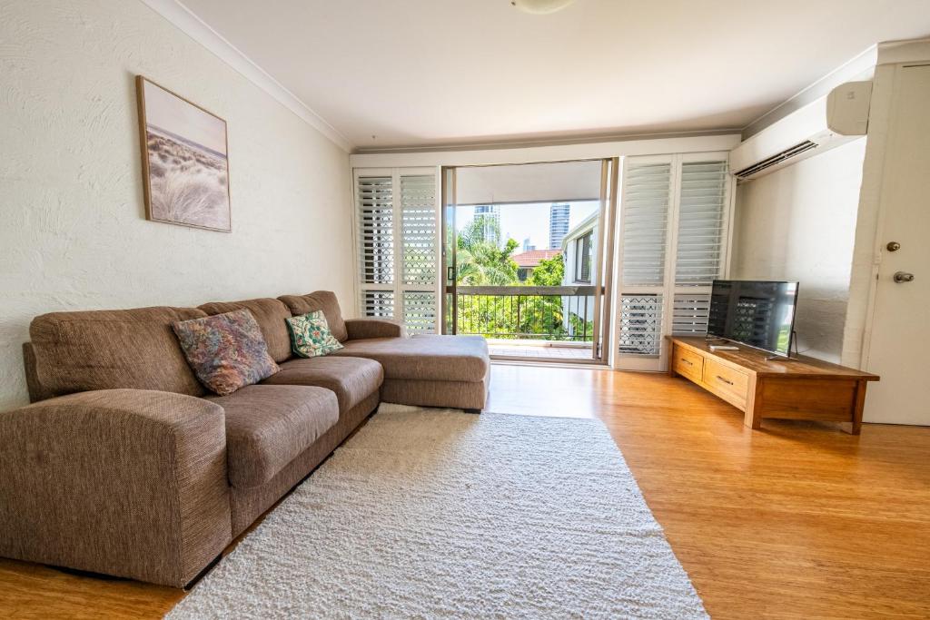 a living room with a couch and a television at Seaside Apartments Broadbeach in Gold Coast