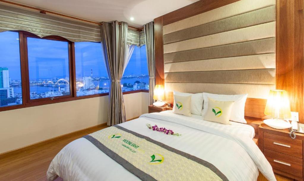 a bedroom with a large bed and a window at Moonlight Hotel & Apartment in Da Nang