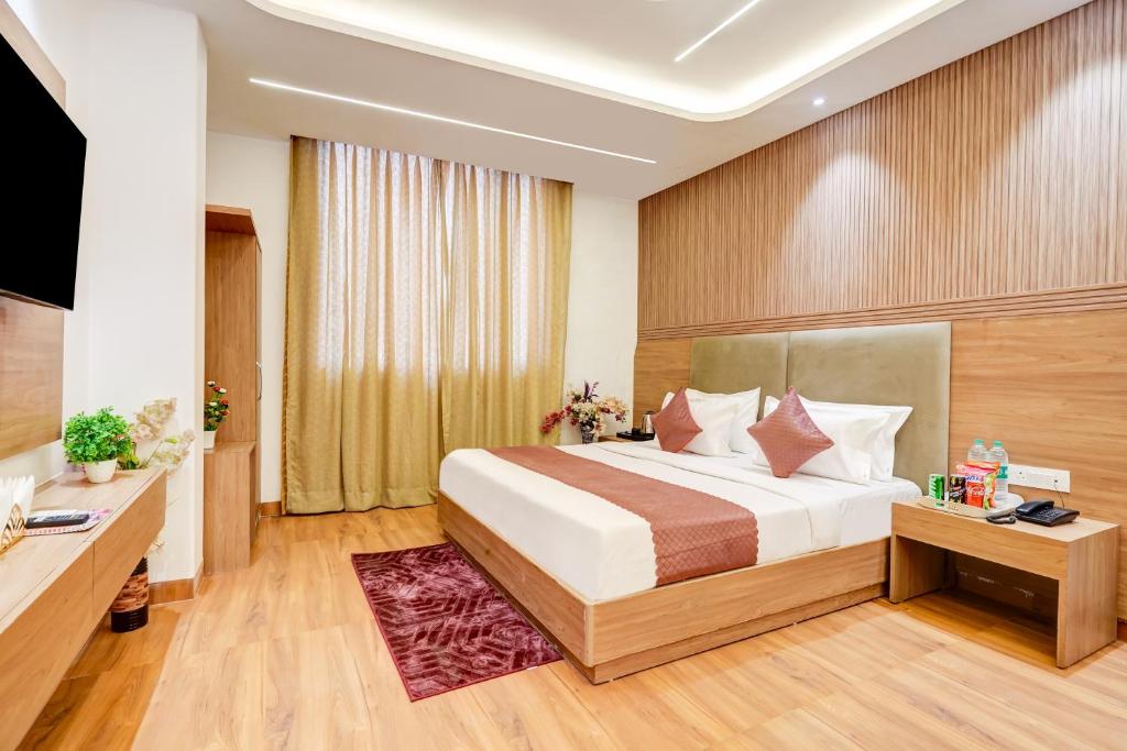 a hotel room with a bed and a television at EL DE Olive Aero Suites Near Delhi International Airport in New Delhi