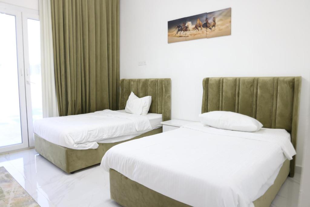 a hotel room with two beds and a window at شالية ماربيا الاشخرة Marbella Ashkhara Chalet in Al Ashkharah
