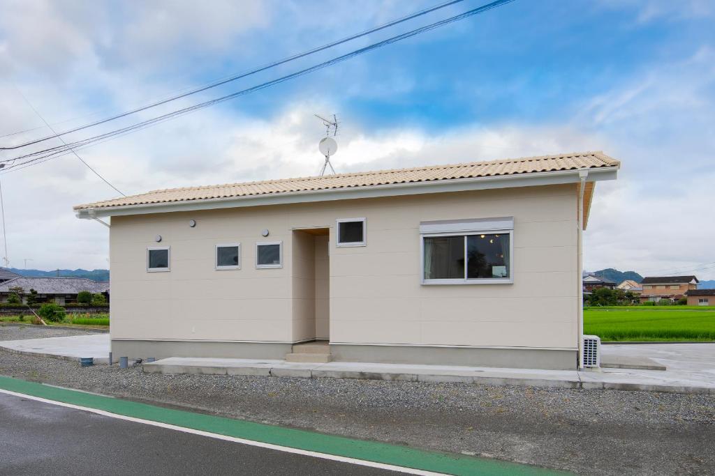 a small white house on the side of a road at RENVI Ukiha ー福岡の宿ー in Ukiha