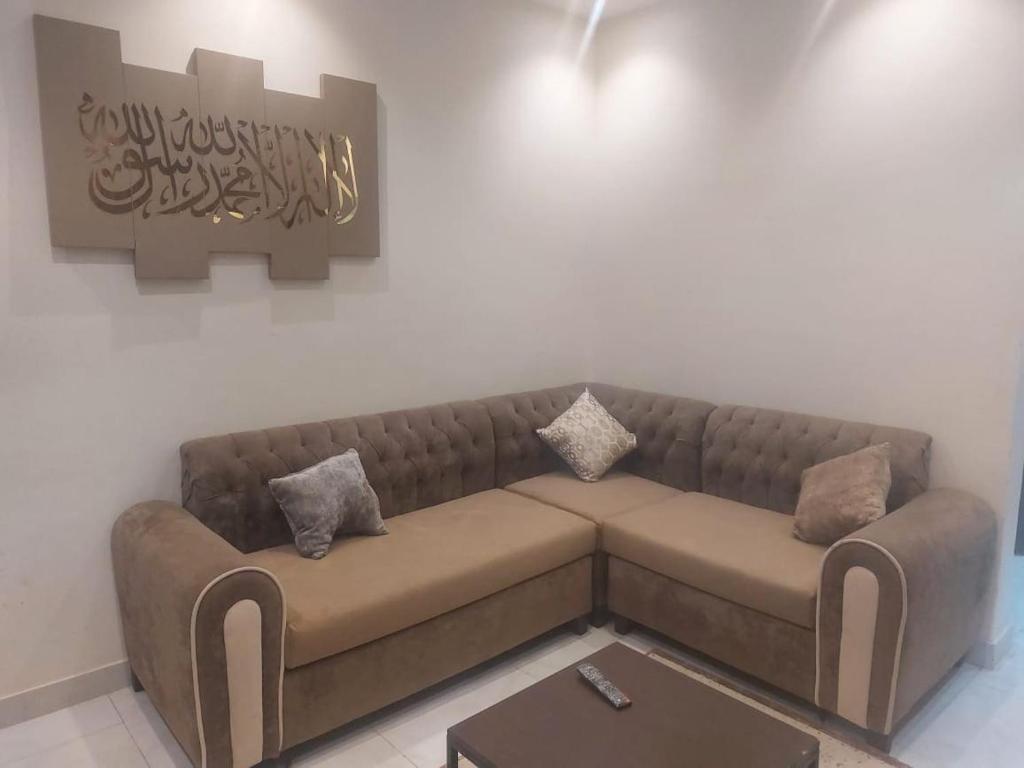 a brown couch in a living room with a table at شقة غرفتين وصالة in Jeddah